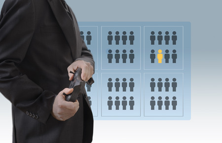 A man is holding a remote control in his hands, in the background there is a screen with User icons. A man is holding a remote control in his hands.の写真素材