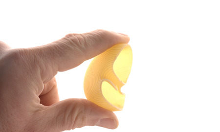 Pasta (Paccheri) are hold by two fingers, isolated on whiteの写真素材