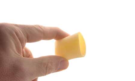 Two fingers hold a noodle (Paccheri), isolated on whiteの写真素材