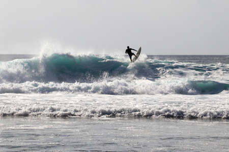surfer rides on a wave on Bali