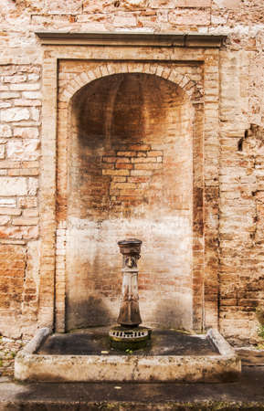 olf italian stone fountain in the village in central Italyの写真素材