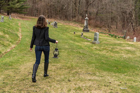 Young woman with lantern walking in the woodの写真素材
