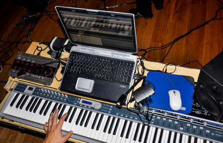 Musician playing on keyboards in a music studio