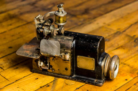 Vintage industrial sewing machine isolated on wooden floor