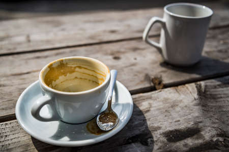 empty coffee cup on wooden table on brown backgroundの写真素材