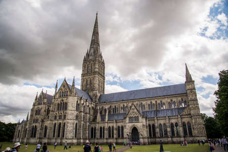 SALISBURY - JULY 17: the famous view of the Cathedral and park on sunny and cloudy day, on July 17, 2015 in Salisbury in South Englandのeditorial素材