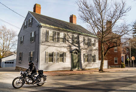 PORTSMOUTH, NH - FEBRUARY 28: Portsmouth, a city in Rockingham County, New Hampshire, is a popular summer destination. Old house with a motorbiker on the street on February 28, 2016のeditorial素材