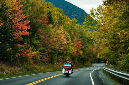 Motorcycle driving on the road on the White Mountains during the fall, New Hampshire, USAの写真素材
