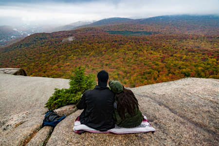 Two hikers watching fall foliage around Mount Washington in New Hampshire, USAの写真素材