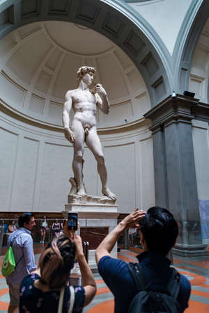 FLORENCE - JUNE 24: Tourists enjoy the vision of the David by Michelangelo inside the Accademia on...