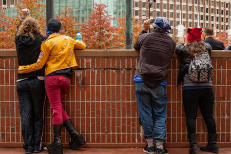 BOSTON, MASSACHUSETTS - OCTOBER 28, 2018: Protester marching for a peace pride rainbow flag at the Boston March for Our Lives political rally.のeditorial素材