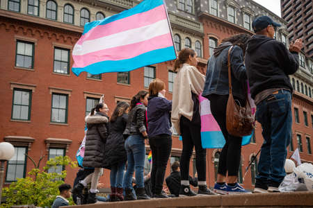 BOSTON, MASSACHUSETTS - OCTOBER 28, 2018: Protester marching for a peace pride rainbow flag at the Boston March for Our Lives political rally.のeditorial素材