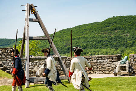 FORT TICONDEROGA, NEW YORK STATE - JUNE 23, 2019: Young men dressed as soldiers, demonstrating how guns were used in fighting the wars that shaped America.のeditorial素材