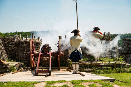 FORT TICONDEROGA, NEW YORK STATE - JUNE 23, 2019: Young men dressed as soldiers, demonstrating how guns were used in fighting the wars that shaped America.のeditorial素材