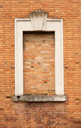 Old wall with a window closed with bricks in Ferrara Italy