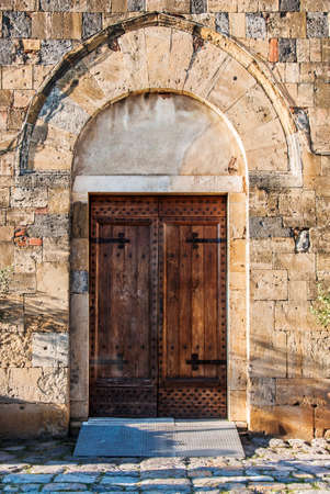 Old italian wooden door in Monteriggioni, Tuscany, Italyの写真素材