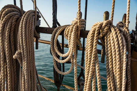 Mooring ropes coiled on fan old boat Strong braided ropes for anchoring the boat in sunset light. Americaの写真素材