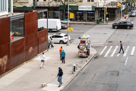 Pedestrian crossing with buildings at the side and few people in New York City on Spring Day