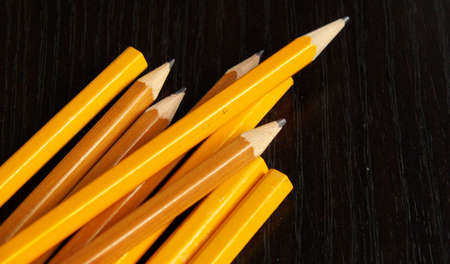 pencils, sharpened and unsharpened, on a black deskの写真素材
