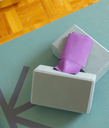 yoga/pilates props: a mat, two blocks and an elastic band on a wooden floorの写真素材