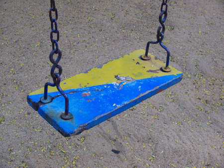 old and ruined wooden swing in a playground