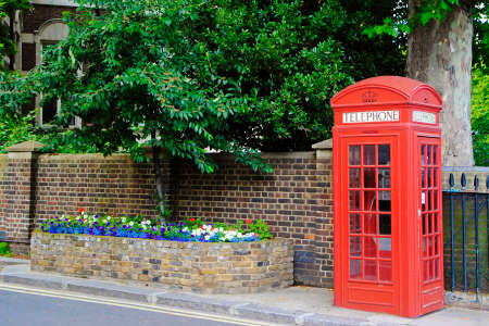 Traditional British red telephone box in a street of London
