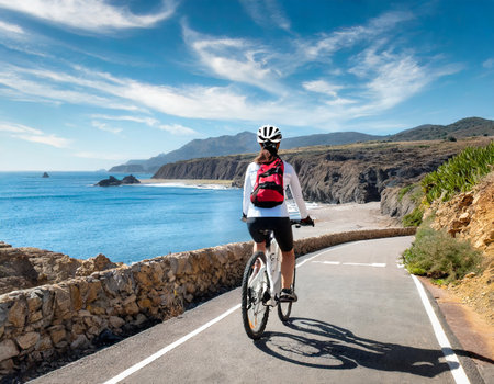 Cyclist Riding the Road on the Atlantic Ocean in Tenerife Canary Islands Spainの素材