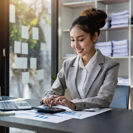 Business woman working with calculator and laptop computer in modern office. Business financial accounting concept.の素材