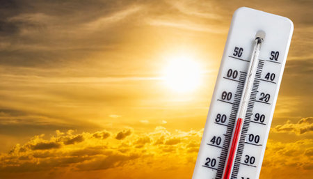 Thermometer on the background of the setting sun. Thermometer shows a high temperature.の素材
