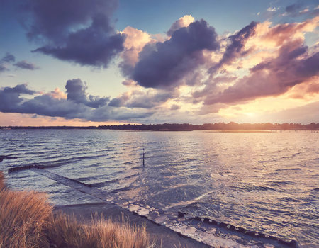 Beautiful sunset over the sea. Dramatic sky. Retro style.の素材