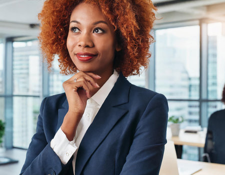 Portrait of a smiling african american businesswoman looking away in officeの素材