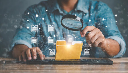Businessman using a magnifying glass to search for documents on the Internetの素材