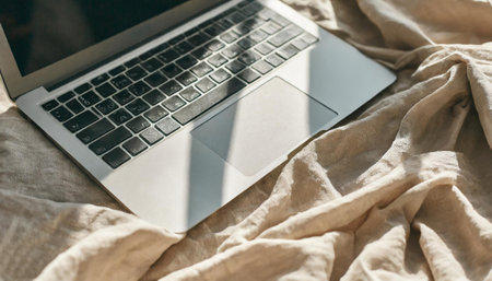 Laptop on the bed in the morning light. Freelance concept.の素材
