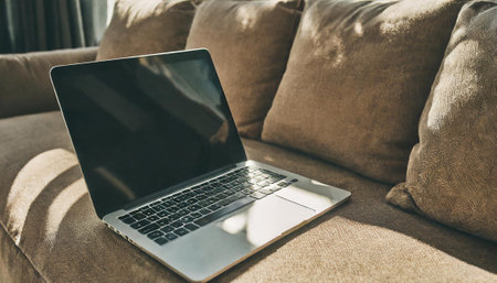 Laptop on sofa in living room with copy space, stock photoの素材