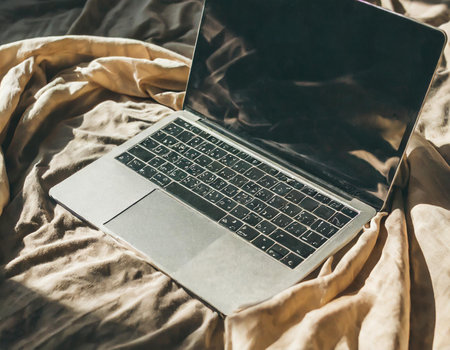 Laptop on the bed in the morning. Laptop on the bed.の素材