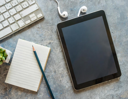 Tablet computer with blank screen, headphones and pencil on concrete backgroundの素材