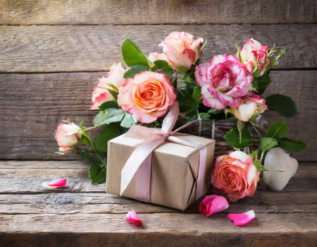 Bouquet of pink roses and gift box on old wooden backgroundの素材
