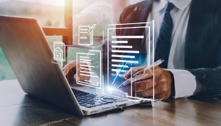 businessman working with laptop computer and document on wooden desk in modern office with virtual icon diagramの素材