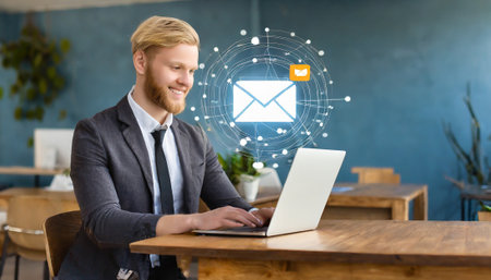Businessman using laptop with email icon on screen. Online communication conceptの素材