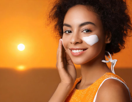 Beautiful young african american woman applying cosmetic cream on her face.の素材
