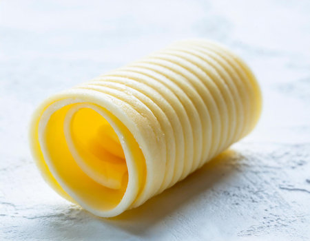 Curls of raw butter on a light background, selective focus.の素材