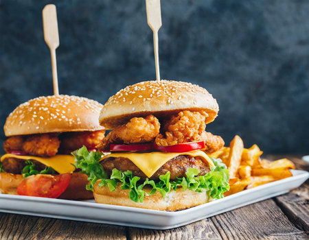 Homemade hamburger with fried chicken and french fries on wooden backgroundの素材