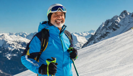 Mature man skier standing on top of the mountain and smilingの素材