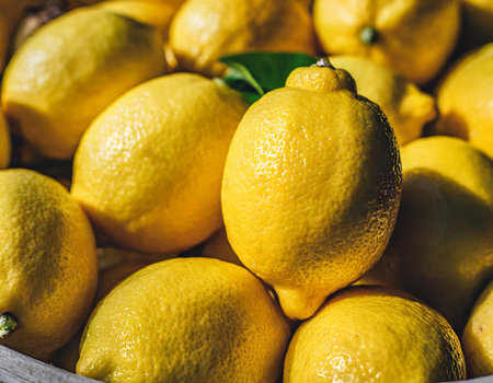 Fresh lemons in a wooden box. Close-up shot.の素材