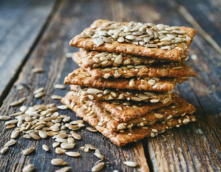 Healthy oatmeal cookies with sunflower seeds on a dark wood background.の素材
