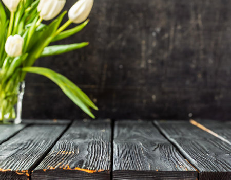 Bouquet of tulips in vase on black wooden backgroundの素材