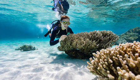 Underwater shot of a young woman scuba diving in coral reefの素材