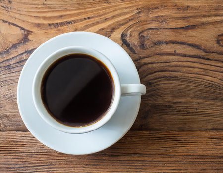 Coffee cup on wooden table. Top view with copy spaceの素材