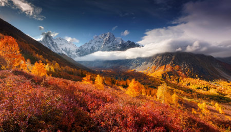 dramatic mountain landscape with vibrant clouds and autumn foliageの素材