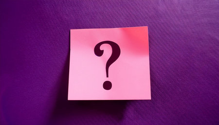 Sticky note with question mark on purple background, close-upの素材